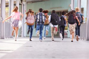 Elementary students running down a hall