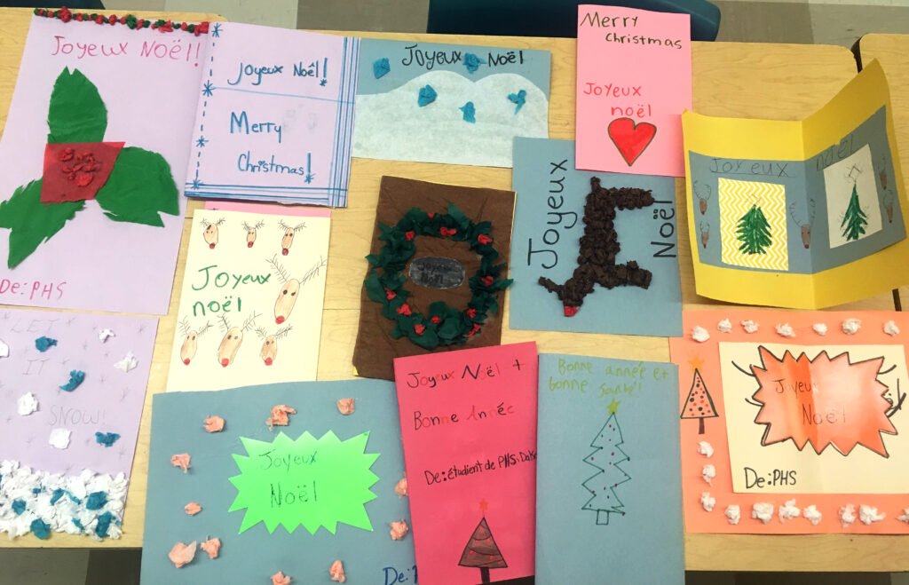 Student-made holiday cards laid out on a table