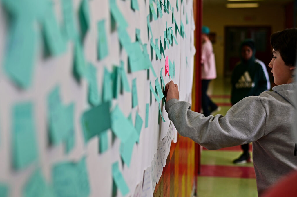 Student places words of kindness on wall