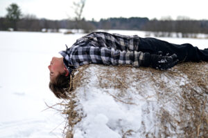 Profile of a student laying on a cylindrical haystack 