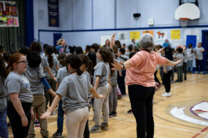 Fellow Grade 3 teacher Ms. Hamilton joins in for the warm-up before the first performance