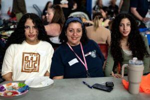 PETES staff volunteer Mahitab Fathy poses with her two daughters seated at a table
