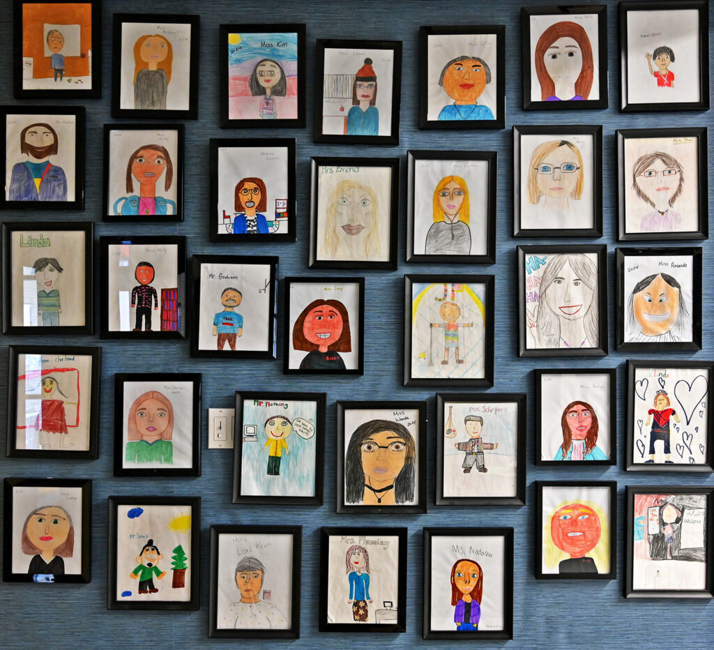 A wall of staff portraits done by elementary school students