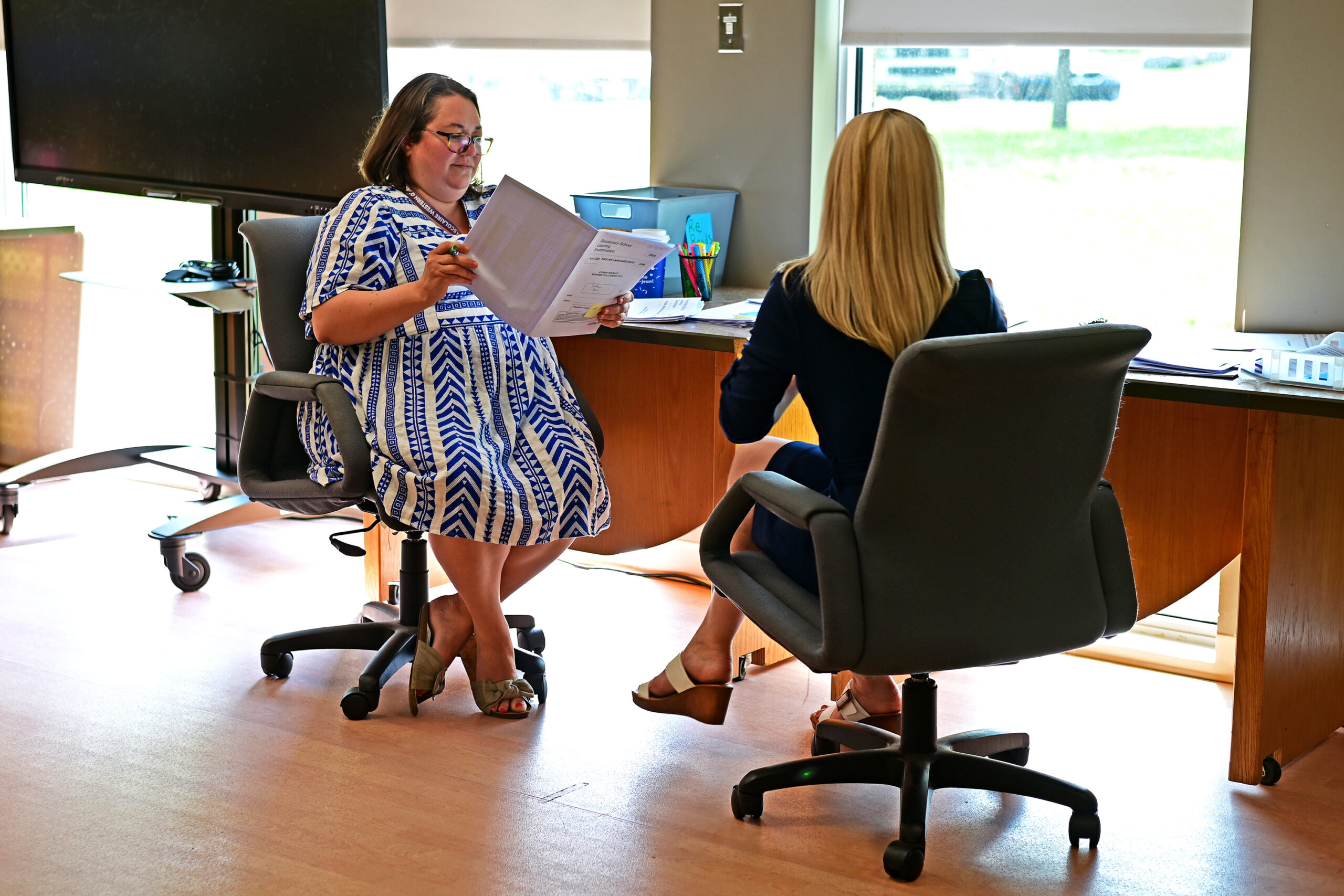 ELA consultants Larissa Sansom and Sarah Kobia sitting at their own table reviewing an exam