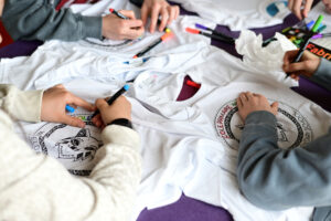 Close-up of students colouring in their t-shirts